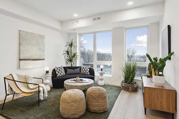 A living room with a large window and a view of trees outside.