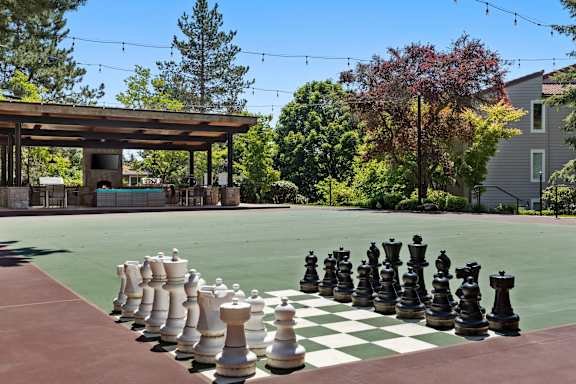 A giant chess board is set up on a tennis court.