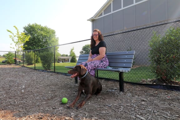 a woman sitting on a bench with her dog