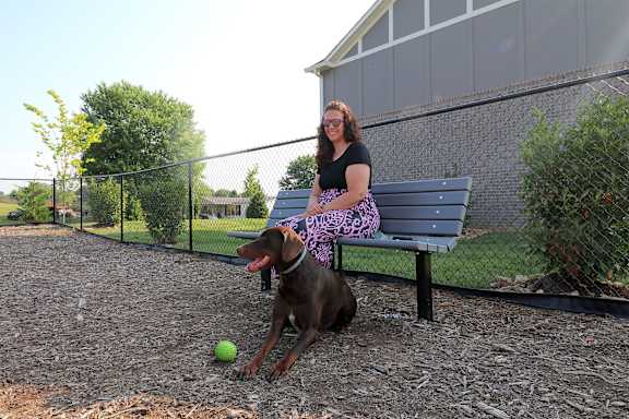 a woman sitting on a bench with her dog