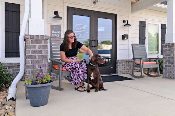 a woman sitting on a bench with her dog