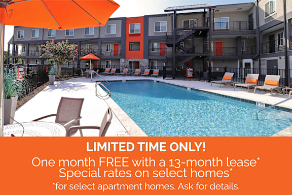 a pool with an orange umbrella in front of an apartment building