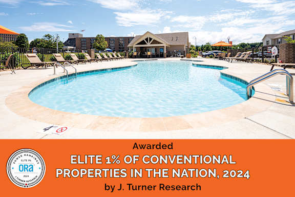 A swimming pool surrounded by lounge chairs and umbrellas with a sign stating it is an award-winning property.