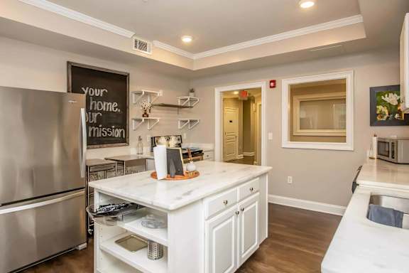 A kitchen with a fridge, microwave, and a sink.
