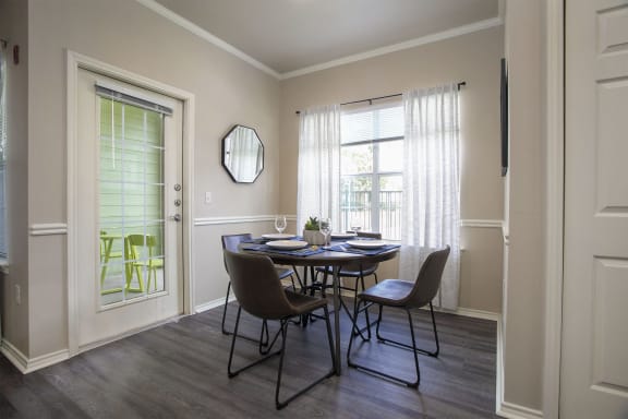 Pet-Friendly Apartments in Tyler, TX - Dining Room with Large WIndow, Plank Wood Flooring and Access to Patio.
