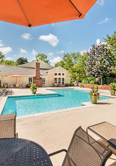 a pool with chairs and tables and a building in the background at Highland Ridge Apartments, Overland Park , KS 66210