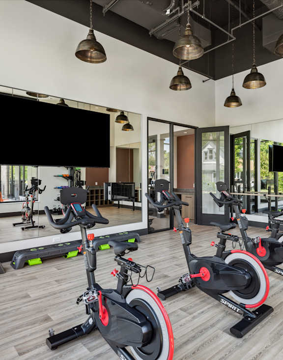 a gym with exercise bikes on the floor and a large window