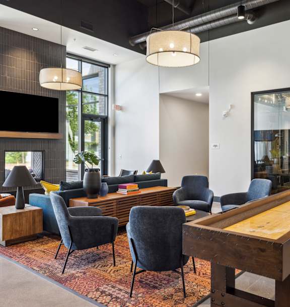 a lounge area with a large table and chairs and a television
