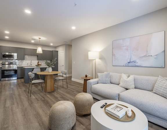 A modern living room with a television, sofas, and a kitchen in the background at Preserve at Sycamore Creek, Osage Beach, Missouri