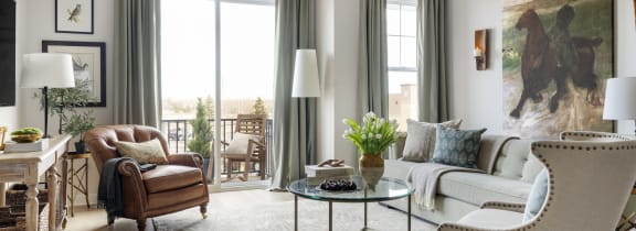 a living room with couches and a table   and a balcony