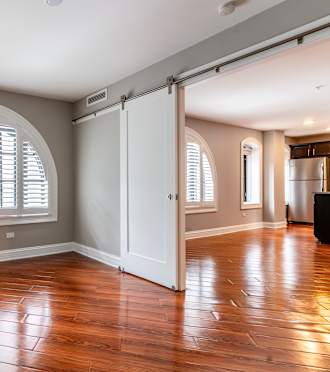 Empty living room with a large window at Somerset Place Apartments, Chicago, IL, 60640
