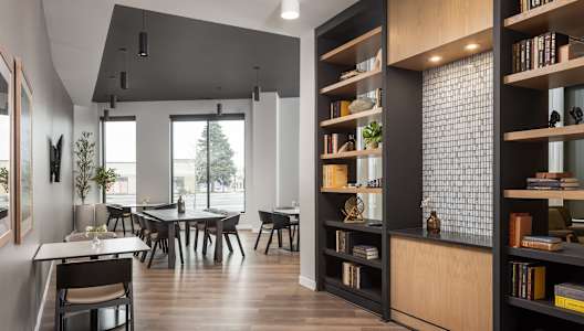 A modern dining room with a long table and chairs.
