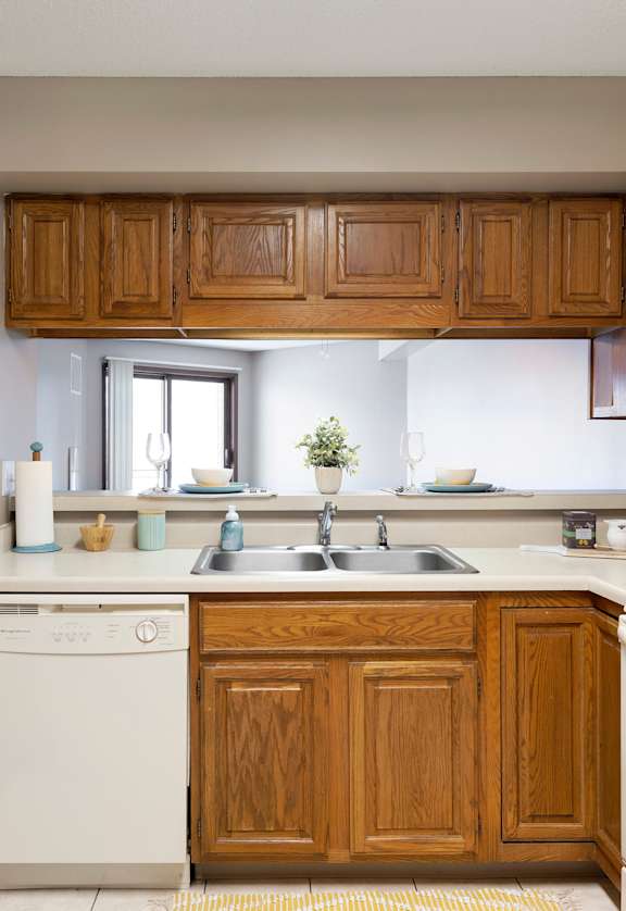 a kitchen with white appliances and wooden cabinets  at The Kendrick, Minnesota, 55108