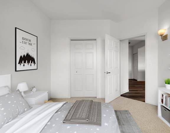 A poster with the text "Adventure is out there" is on the wall above a bed in a room.