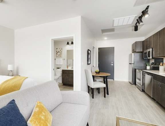a living room and kitchen with a couch and a table