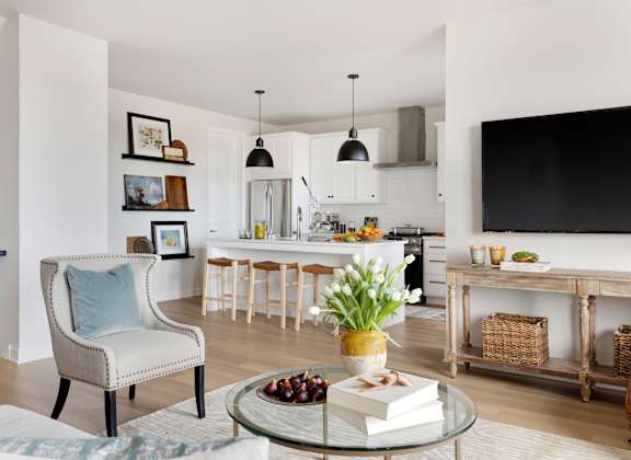a living room and kitchen with a table and chairs and a television