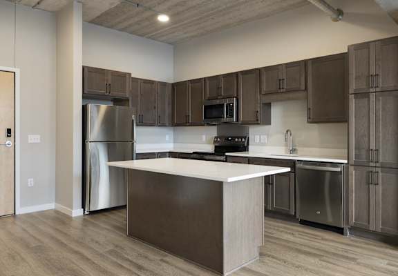 A modern kitchen with wooden cabinets and stainless steel appliances.