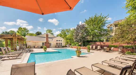 a pool with chairs and tables and a building in the background at Highland Ridge Apartments, Overland Park , KS 66210