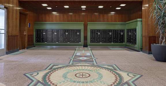the lobby of a building with two vending machines and a rug in the floor