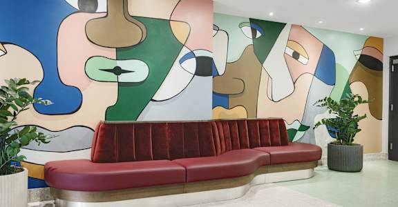 a lobby with a couch and a painting on the wall