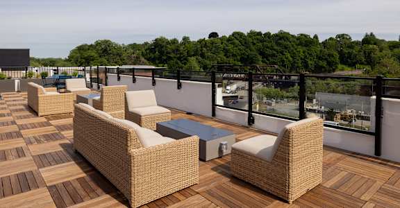 A patio with wicker furniture and a table.