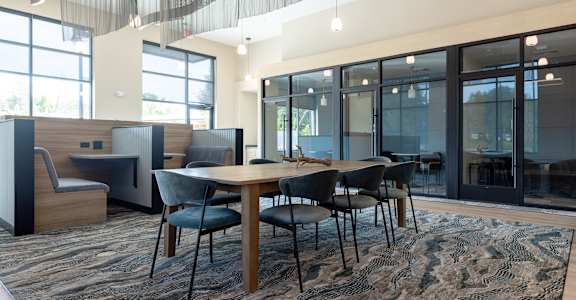 A conference room with a long table surrounded by chairs.