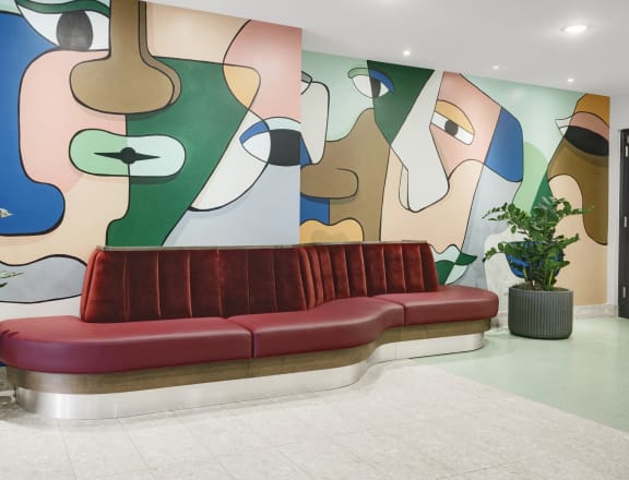 a lobby with a couch and a painting on the wall