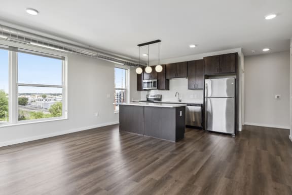 an open kitchen with a large window and a stainless steel refrigerator
