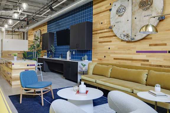 a living room with a couch and a kitchen with a table and chairs