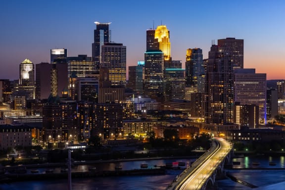 a cityscape of a city at night with a bridge and highways at Expo, Minneapolis, MN