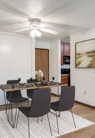 a dining room with a table and chairs and a ceiling fan