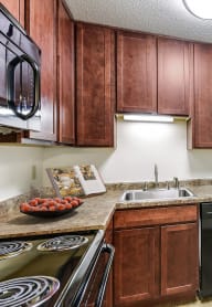 a kitchen with black appliances and wooden cabinets