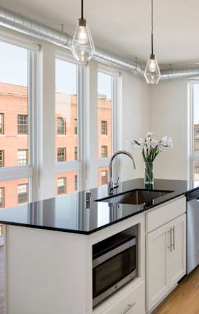 A kitchen with black countertops and white cabinets.