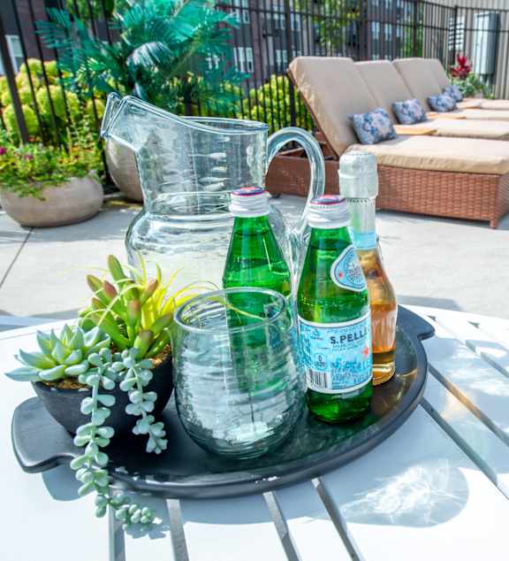 a tray with two bottles of beer on a patio table