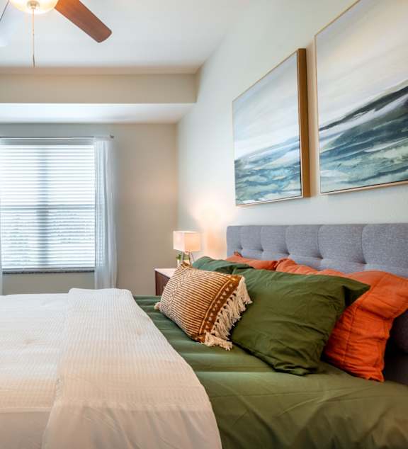 a bedroom with a large bed and a ceiling fan