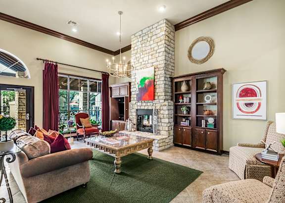 A living room with a fireplace and a green rug.