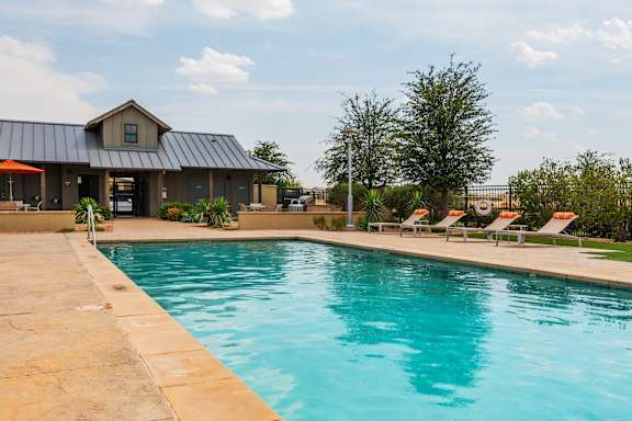 A large swimming pool in front of a house.