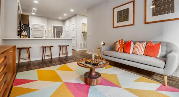 A living room with a grey couch and a wooden coffee table.
