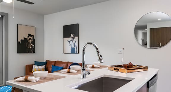 A modern kitchen with a white countertop and a brown tray on it.