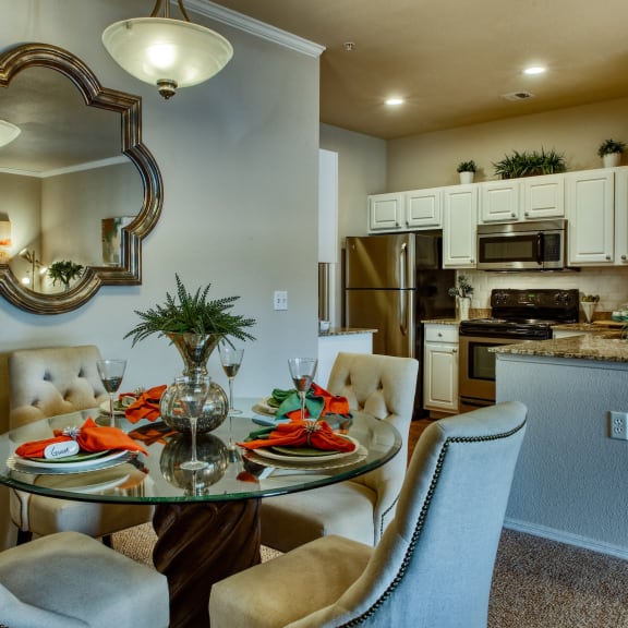 a dining room with a table and chairs next to a kitchen