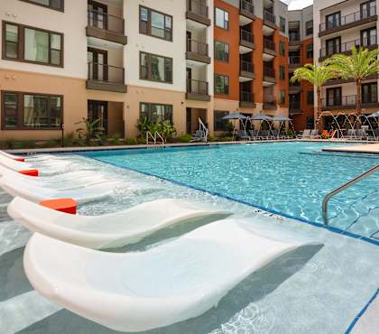 A swimming pool with a slide in front of a building.