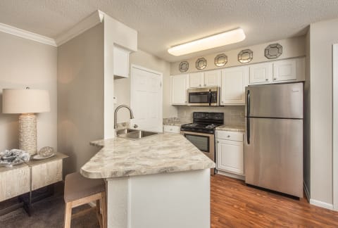 a kitchen with stainless steel appliances and a marble counter top at Highland Ridge Apartments, Overland Park , KS 66210