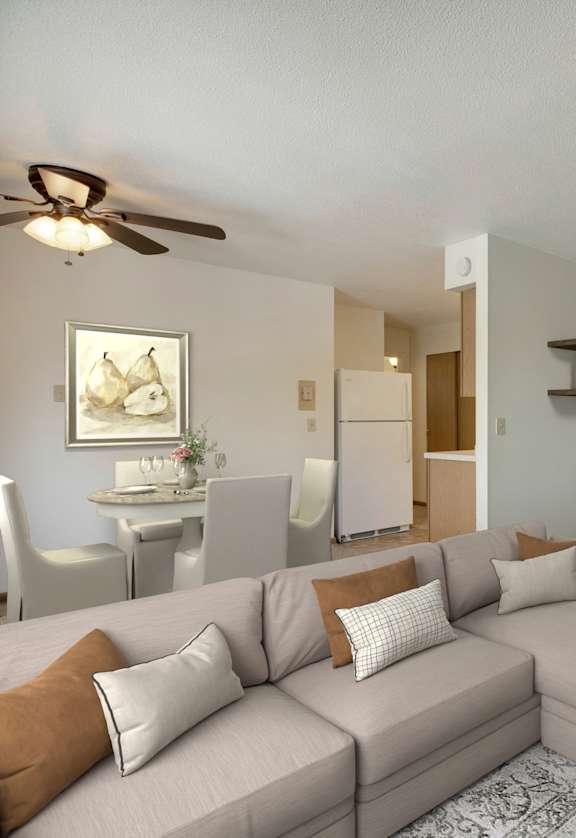 A living room with a grey couch, a coffee table, and a ceiling fan.