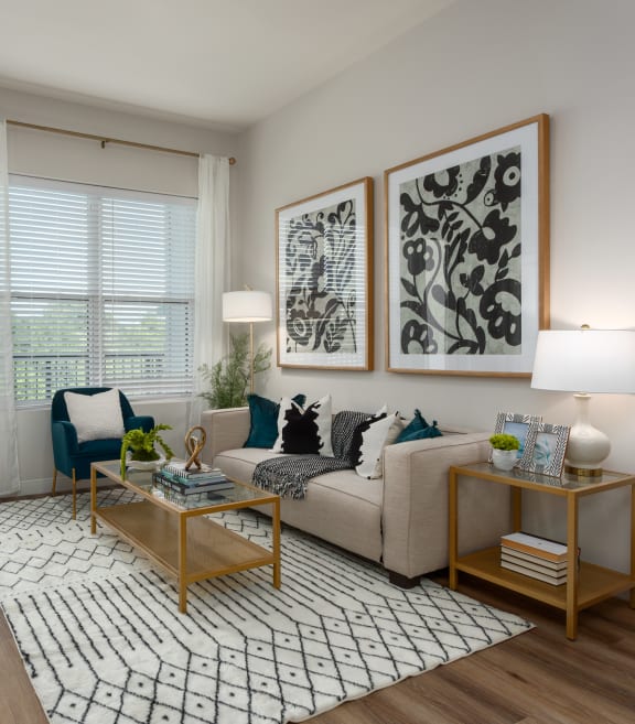 Modern living room with a couch coffee table, large window a door leading to a balcony  at Chapter at the Streets of St Charles, Saint Charles, 63303