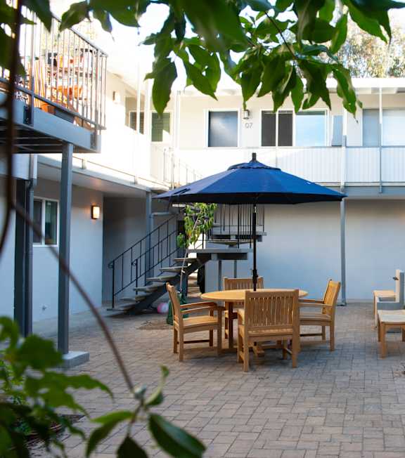 a patio with chairs and a table in a courtyard