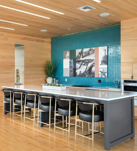 A modern kitchen with a bar area and a refrigerator.