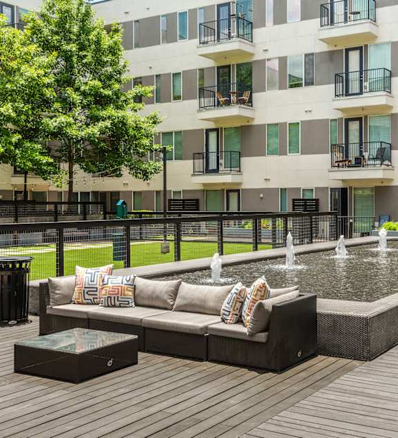 A modern outdoor seating area with a fountain and benches.