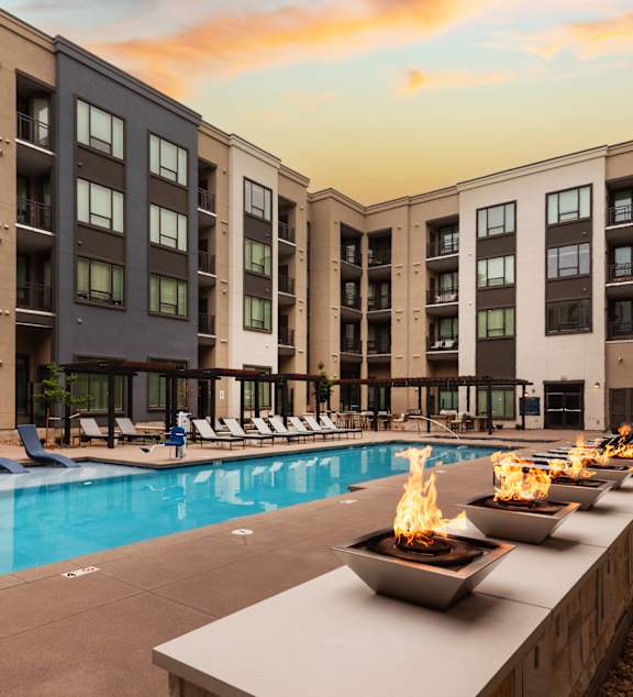 A pool with a fire pit in the middle of it.