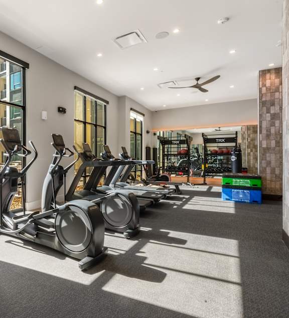 A gym with treadmills, elliptical machines, and other exercise equipment.