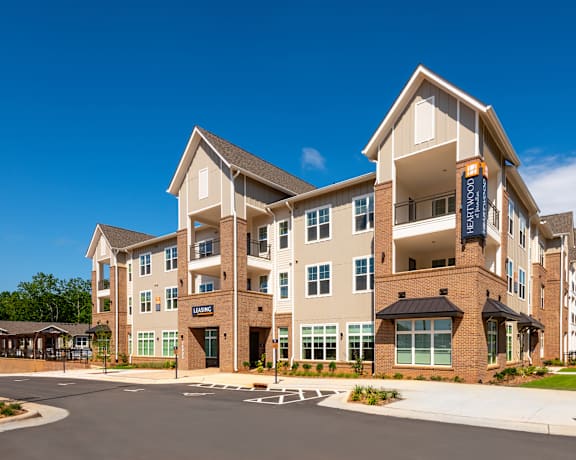 A large, modern apartment building with a clear blue sky above.